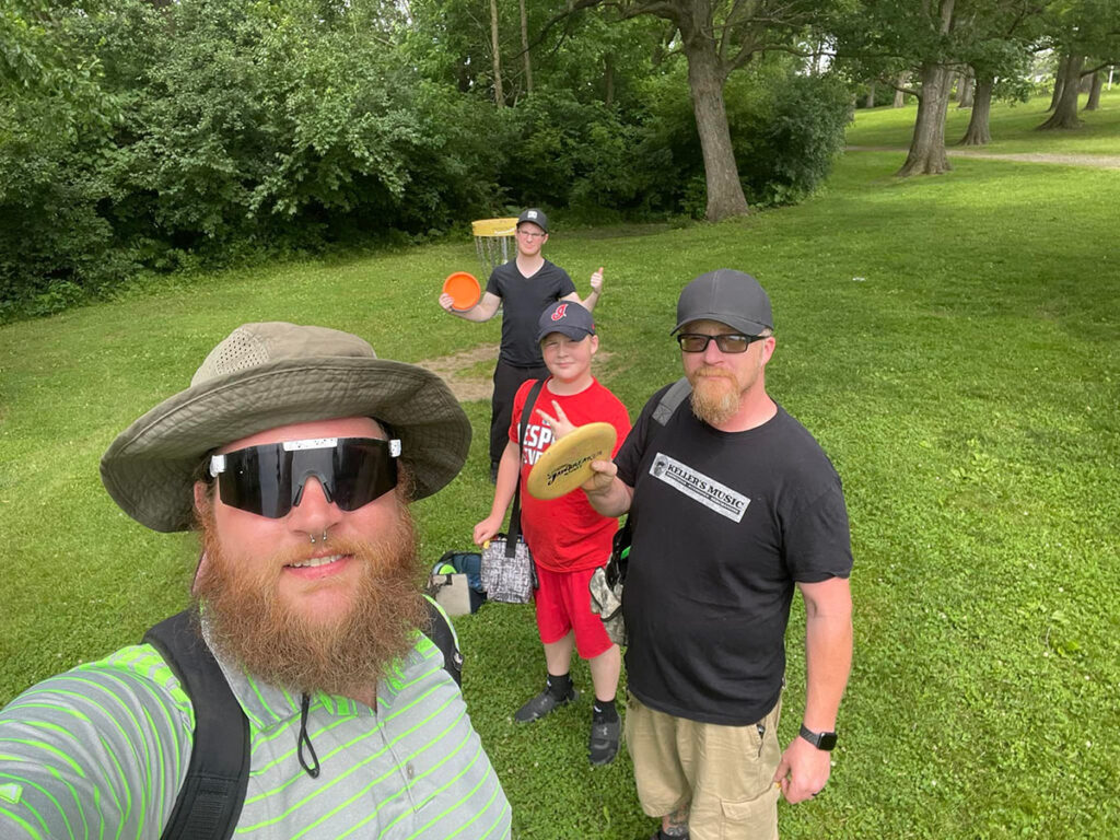 A group of guys playing disc golf.