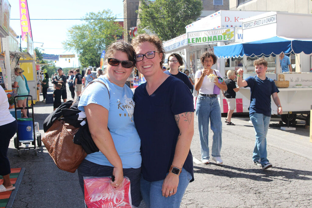 Two women posing for a photo among a crowd at the Popcorn Festival in Marion.