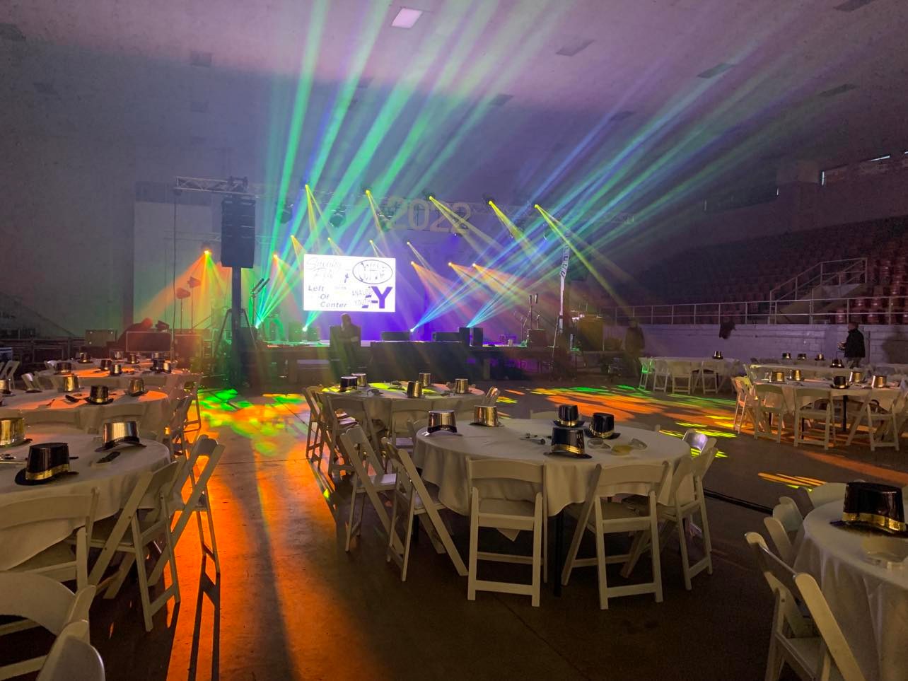 stage lights, sound equipment, and decorated tables with chairs