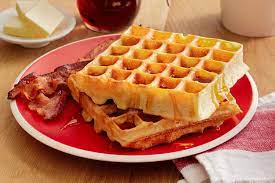 waffles on a red plate with bacon