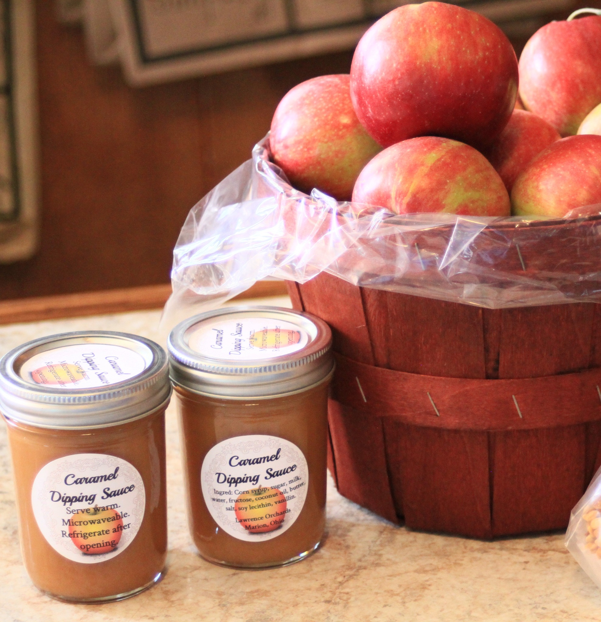 jars of caramel apple sauce and a basket of apples