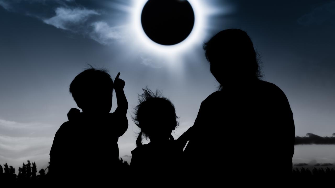 family looking up at solar eclipse