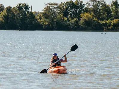 Woman kayaking on Foundation Lake at Tallgrass Trail