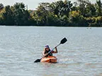 Woman kayaking on Foundation Lake at Tallgrass Trail