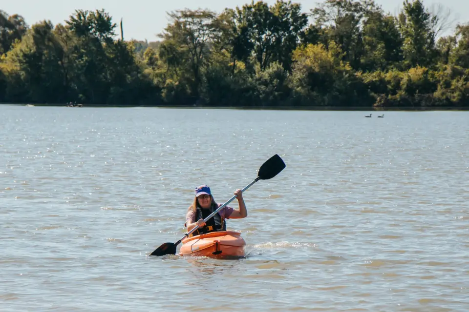 Woman kayaking on Foundation Lake at Tallgrass Trail